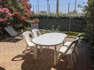 a white table and four chairs and a table and chairs at Charmante Maison T2 Mezzanine avec Jardin et Parking, à 500m de la Plage - 6 Pers. - FR-1-797-46 in Port-la-Nouvelle