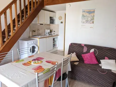 a kitchen and a living room with a table and a couch at Charmante Maison T2 Mezzanine avec Jardin et Parking, à 500m de la Plage - 6 Pers. - FR-1-797-46 in Port-la-Nouvelle
