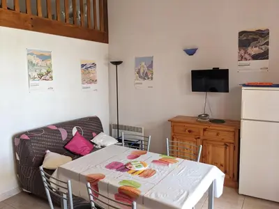 a living room with a table and a couch at Charmante Maison T2 Mezzanine avec Jardin et Parking, à 500m de la Plage - 6 Pers. - FR-1-797-46 in Port-la-Nouvelle