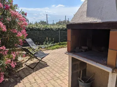 a brick patio with an outdoor oven in a garden at Charmante Maison T2 Mezzanine avec Jardin et Parking, à 500m de la Plage - 6 Pers. - FR-1-797-46 in Port-la-Nouvelle