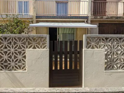 a metal fence in front of a house at Villa T3 climatisée, 57m², 5/6 pers, proche plage, rénovée, terrasse, parking, quartier animé - FR-1-797-48 in Port-la-Nouvelle