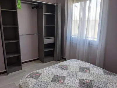 a bedroom with a bed and some shelves and a window at Villa T3 climatisée, 57m², 5/6 pers, proche plage, rénovée, terrasse, parking, quartier animé - FR-1-797-48 in Port-la-Nouvelle