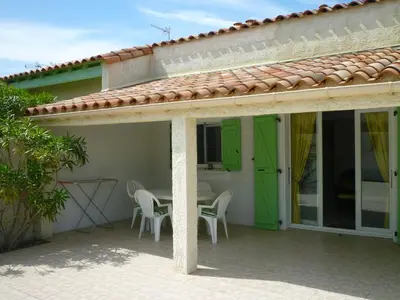 a house with a patio with a table and chairs at Superbe villa T4 confort avec cour, proche plage - 6 Pers. Parking - FR-1-797-47 in Port-la-Nouvelle