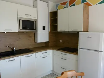 a kitchen with white cabinets and a sink and a refrigerator at T2 Moderne Port-la-Nouvelle - 4/5p - Parking - Front de Mer - FR-1-797-41 in Port-la-Nouvelle