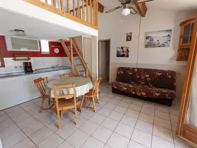 a kitchen and a living room with a table and chairs at Maison T2 avec Mezzanine, Cour et Parking – 5 Pers – Proche Plage et Commerces – Bon Prix - FR-1-797-49 in Port-la-Nouvelle