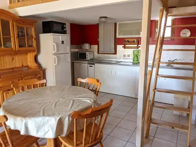 a kitchen with a table and a white refrigerator at Maison T2 avec Mezzanine, Cour et Parking – 5 Pers – Proche Plage et Commerces – Bon Prix - FR-1-797-49 in Port-la-Nouvelle