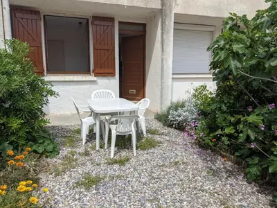 a table and chairs in front of a house at T2 Climatisé, 2 Cours, Proche Plage, Parking Privé, 5 Pers., Animaux Acceptés - FR-1-797-58 in Port-la-Nouvelle