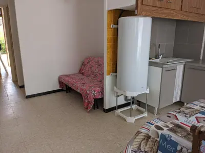 a living room with a chair and a sink at T2 Climatisé, 2 Cours, Proche Plage, Parking Privé, 5 Pers., Animaux Acceptés - FR-1-797-58 in Port-la-Nouvelle