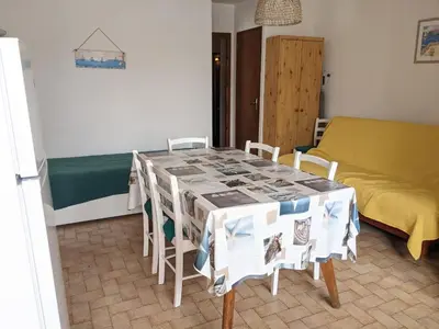 a room with a table with chairs and a bed at Villa T2 climatisée, 5 pers, proche plage, cour, jardin, barbecue, parking, 2* Meublés Tourisme - FR-1-797-57 in Port-la-Nouvelle