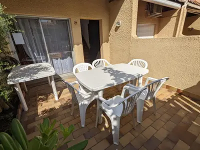 a white table and chairs on a patio at Villa T3 Mezzanine Climatisée, Proche Plage, Parking et Terrasse - 6 Pers - FR-1-797-56 in Port-la-Nouvelle