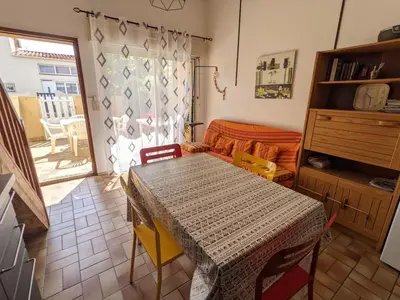 a living room with a table and a couch at Villa T3 Mezzanine Climatisée, Proche Plage, Parking et Terrasse - 6 Pers - FR-1-797-56 in Port-la-Nouvelle