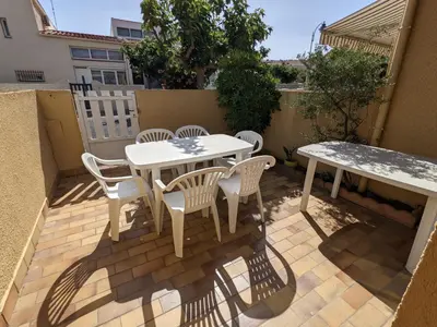 a white table and chairs on a patio at Villa T3 Mezzanine Climatisée, Proche Plage, Parking et Terrasse - 6 Pers - FR-1-797-56 in Port-la-Nouvelle