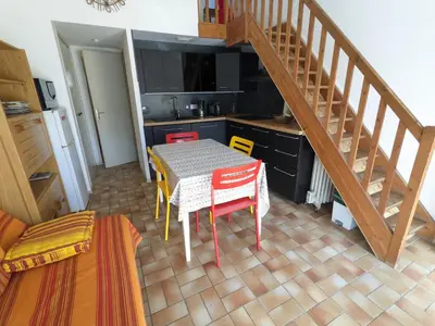 a kitchen with a table and a kitchen with a staircase at Villa T3 Mezzanine Climatisée, Proche Plage, Parking et Terrasse - 6 Pers - FR-1-797-56 in Port-la-Nouvelle