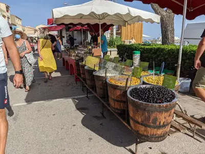 a group of people standing around a market with grapes in barrels at Villa T2 cosy, 40m², 4 pers, proche plage, 2 terrasses, tout équipé, calme et commerces à proximité - FR-1-797-53 in Port-la-Nouvelle