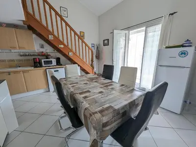 a kitchen with a wooden table with chairs around it at Villa T3 Spacieuse à Port-la-Nouvelle – Jardin, Parking, à 900m de la Plage, Chien Admis - FR-1-797-50 in Port-la-Nouvelle