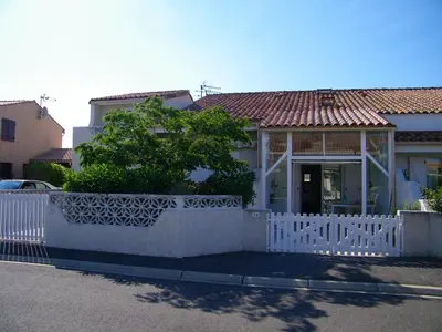 a white fence in front of a house at maison pour vacance a la mer in Port-la-Nouvelle