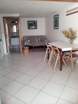 a living room with a table and a couch at maison pour vacance a la mer in Port-la-Nouvelle