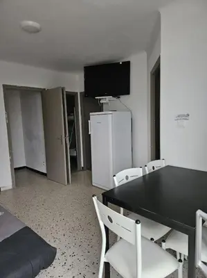 a room with a black table and white chairs at Gruissan plage des chalets petit logement en rdc in Gruissan