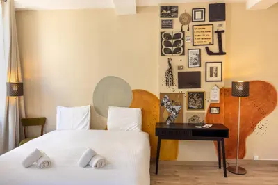 two beds in a room with a wall of pictures at Le Grand Authentique in Carcassonne
