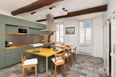 a kitchen with a wooden table and chairs at Le Grand Authentique in Carcassonne