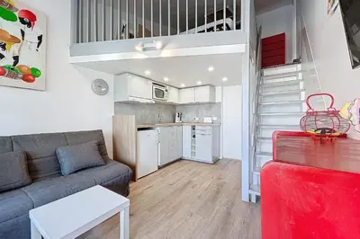 a living room with a couch and a kitchen at Studio with pool near the harbor in Gruissan