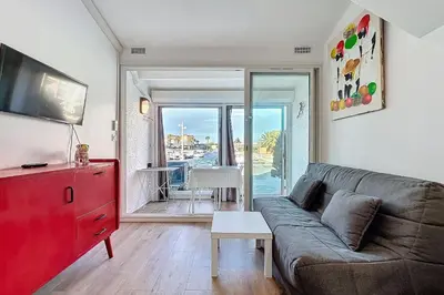 a living room with a couch and a red dresser at Studio with pool near the harbor in Gruissan