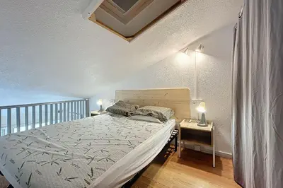 a bedroom with a bed and a night stand with two lamps at Studio with pool near the harbor in Gruissan