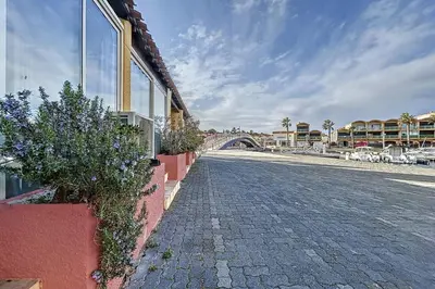 a cobblestone street with a bridge in the background at Studio with pool near the harbor in Gruissan