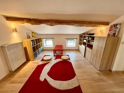 a living room with a red and white rug at La circulade - Maison de caractère avec jardin in Bram