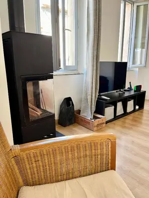 a living room with a fireplace and a couch at La circulade - Maison de caractère avec jardin in Bram