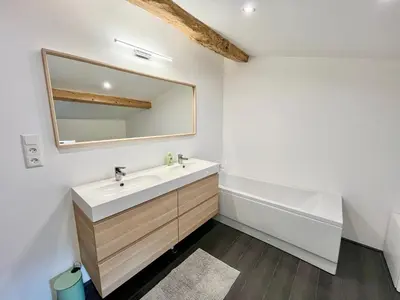 a bathroom with a sink and a mirror and a tub at La circulade - Maison de caractère avec jardin in Bram