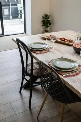 a wooden table with two chairs and plates on it at L'atelier de 1900 in Puicheric