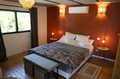 a bedroom with a large bed and two windows at L'atelier de 1900 in Puicheric