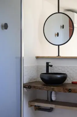 a bathroom with a black sink and a mirror at L'atelier de 1900 in Puicheric