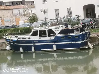 a blue and white boat sitting in the water at Appartement bateau Narbonne in Narbonne