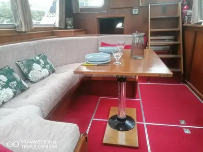 a living room with a couch and a table at Appartement bateau Narbonne in Narbonne
