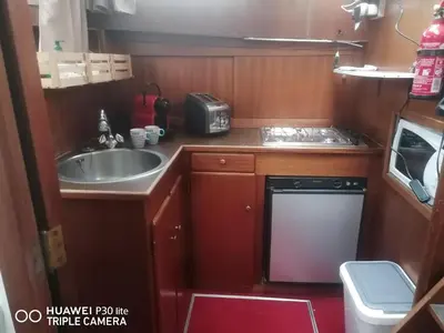 a small kitchen with a sink and a dishwasher at Appartement bateau Narbonne in Narbonne