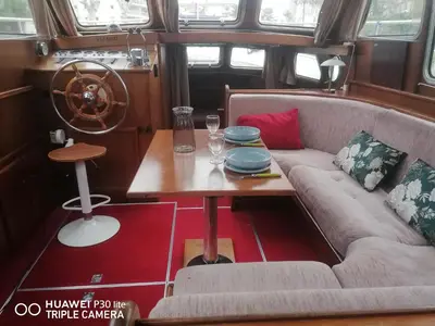 a living room with a couch and a table at Appartement bateau Narbonne in Narbonne