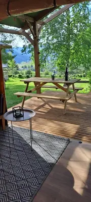 a picnic table sitting on a wooden deck with a table at Lodge Safari tent in Camurac