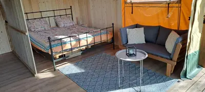 a room with a bed and a couch and a table at Lodge Safari tent in Camurac