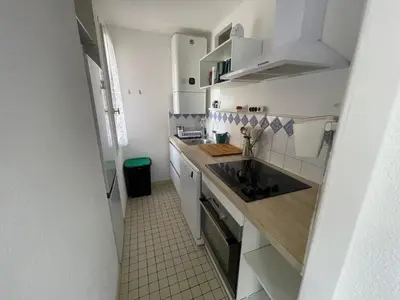 a small kitchen with white cabinets and a sink at Appartement T2 à Gruissan, RDC, Plage à 150m, Parking, 4-5 pers - FR-1-796-72 in Gruissan