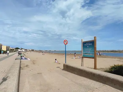 a sign on a beach with people on the sand at Appartement T2 à Gruissan, RDC, Plage à 150m, Parking, 4-5 pers - FR-1-796-72 in Gruissan
