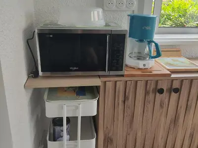 a microwave sitting on top of a wooden cabinet at Appartement T2 à Gruissan, RDC, Plage à 150m, Parking, 4-5 pers - FR-1-796-72 in Gruissan