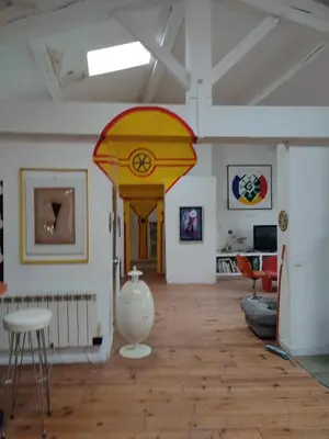 a living room with a white vase on a wooden floor at Loft au piémont des Pyrénées Cathares in Sainte-Colombe-sur-lʼHers