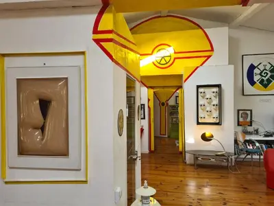 a hallway with several different types of art on the walls at Loft au piémont des Pyrénées Cathares in Sainte-Colombe-sur-lʼHers