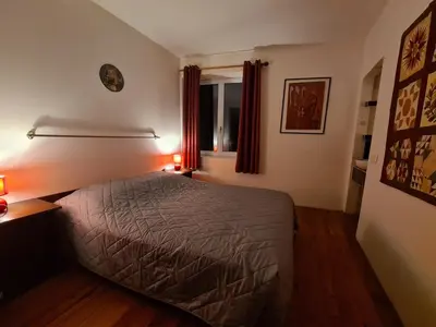 a bedroom with a bed and a window with red lights at Loft au piémont des Pyrénées Cathares in Sainte-Colombe-sur-lʼHers