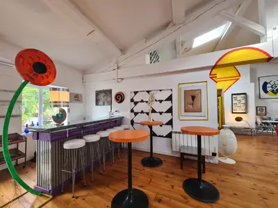a room with a bar with stools in it at Loft au piémont des Pyrénées Cathares in Sainte-Colombe-sur-lʼHers