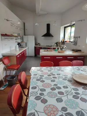 a kitchen with a table and red chairs and a kitchen with a table at Loft au piémont des Pyrénées Cathares in Sainte-Colombe-sur-lʼHers