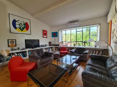 a living room with couches and chairs and a television at Loft au piémont des Pyrénées Cathares in Sainte-Colombe-sur-lʼHers