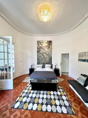 a bedroom with a bed and a rug at SUNNY , terrasse, climatisation, centre ville in Carcassonne
